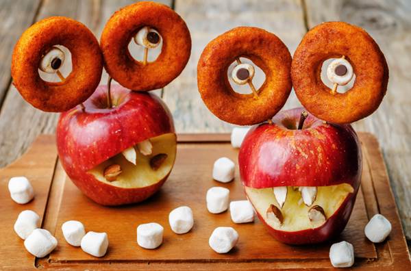 apples, marshmallows and donuts in the shape of monsters for Halloween for kids. the toning. selective focus