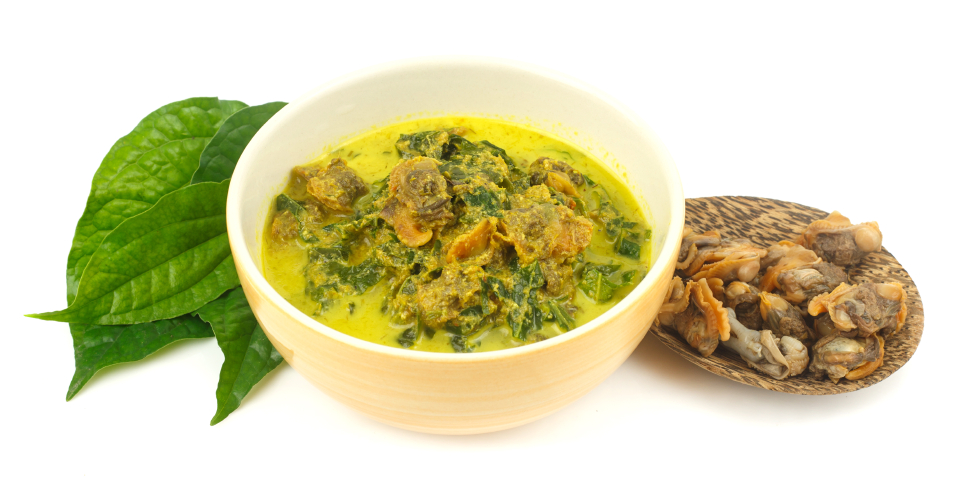 Bowl of cockle curry with betel leaves on white background