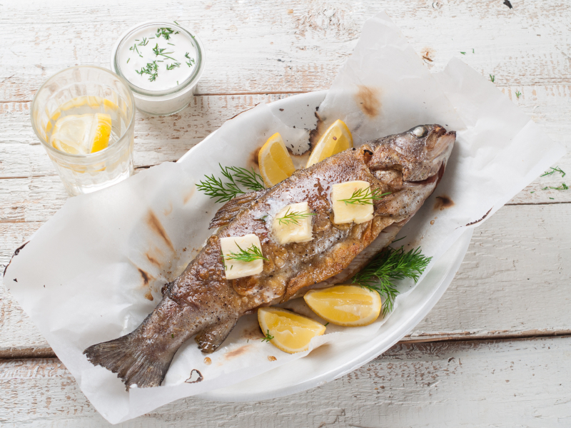 Grilled fish with butter and lemon, selective focus