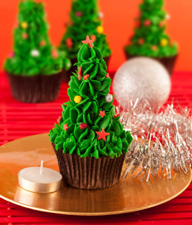 Several christmas tree cupcakes on a table