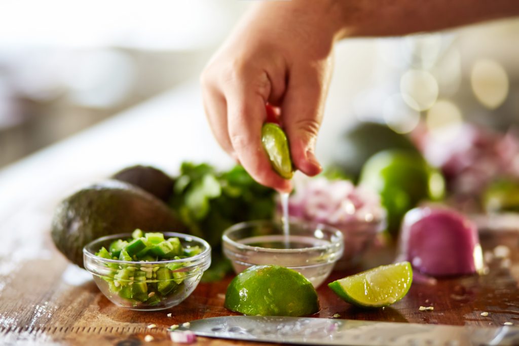 squeezing lime juice for guacamole recipe prep shot close up with selective focus