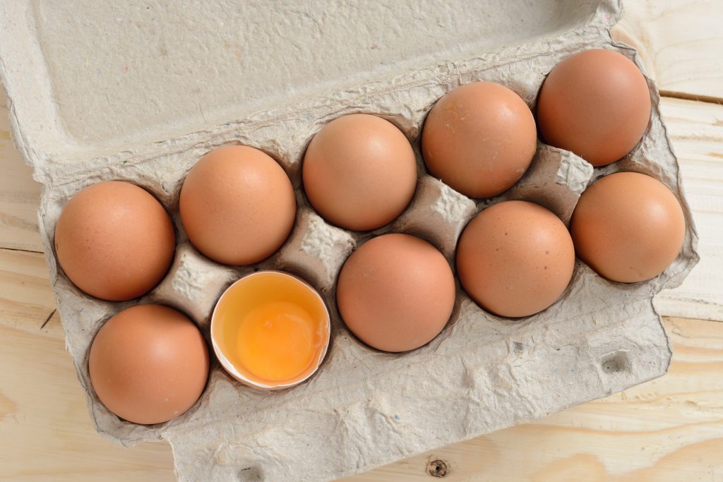 Overhead view of Brown eggs in carton.
