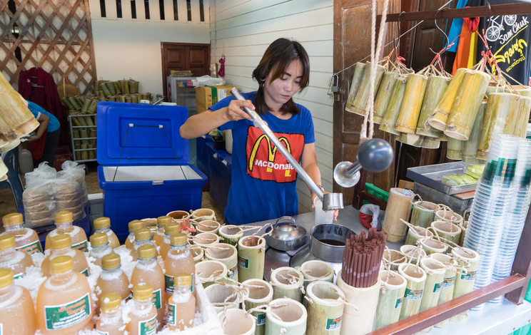 Suphanburi, Thailand - October 24, 2015: A girl is selling palm juice in Samchuk market.